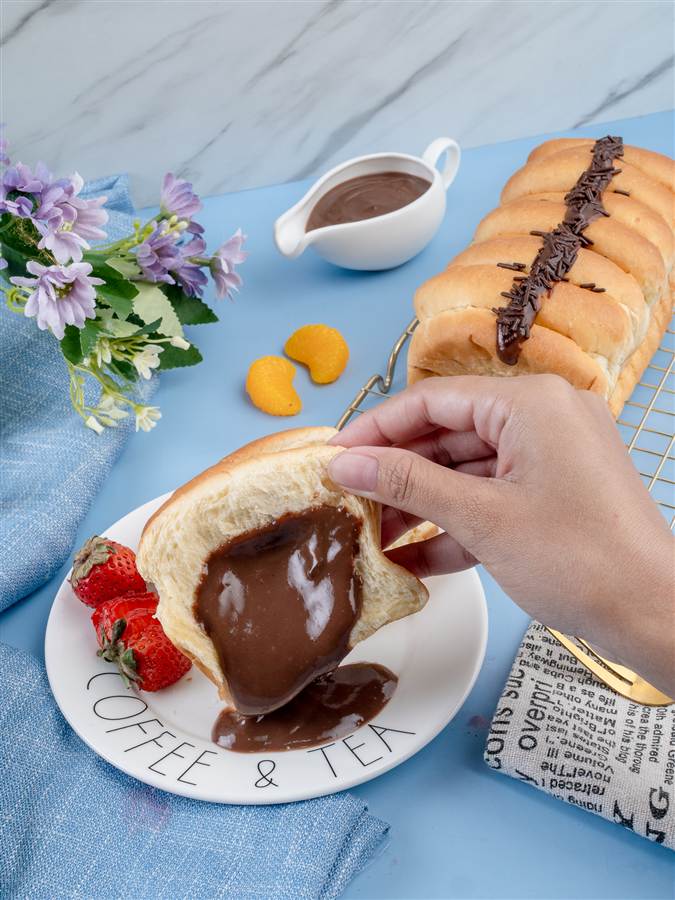 Hand tearing bread with melted chocolate filling, Forisa