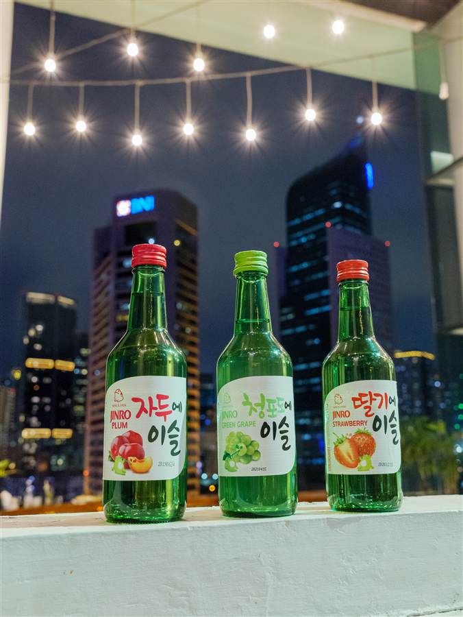 Three soju bottles against the Jakarta skyline at night, Jinro
